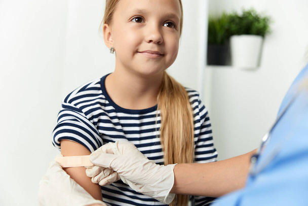 der Arzt versiegelt die Hand des Kindes mit einem Gips in Nahaufnahme - Foto, Bild