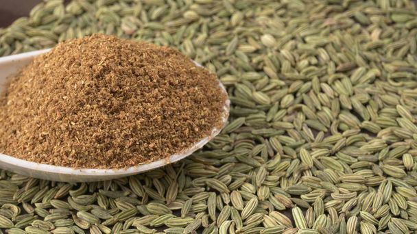 Ground cumin in a bowl and whole cumin, Jeera, on the wooden background. selective focus. - Photo, Image
