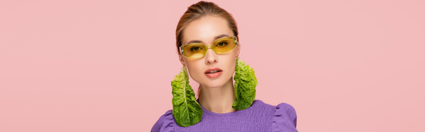 mladá žena v barevných brýlích a čerstvé salátové náušnice izolované na růžové, banner - Fotografie, Obrázek
