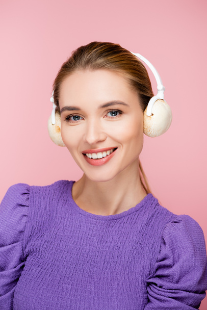 Χαρούμενη γυναίκα με μανιτάρια σε ακουστικά κοιτάζοντας κάμερα απομονωμένη σε ροζ - Φωτογραφία, εικόνα