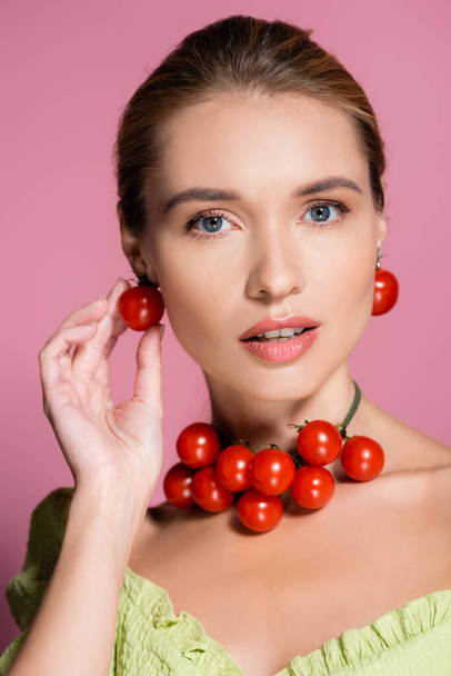sensual woman in necklace and earrings made of red cherry tomatoes on pink - Photo, Image