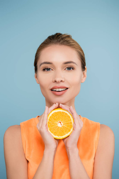 hymyilevä nainen luonnollinen meikki tilalla puolet kypsä oranssi eristetty sininen - Valokuva, kuva