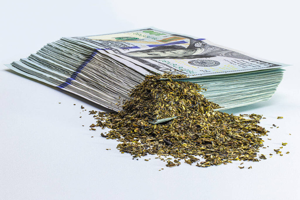 Marijuana on the background of a bundle of hundred dollar bills. Cannabis business concept. Marijuana and money. Drugs - Photo, Image