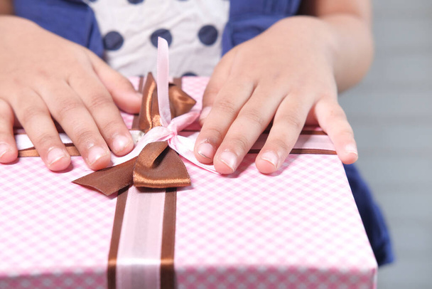 Anneler günü konsepti, çocuk eli pembe renk hediye kutusu.  - Fotoğraf, Görsel
