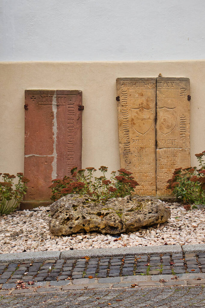 Losas, rocas y flores decoran el lado de una casa en Florsheim Dalsheim, Alemania. - Foto, imagen