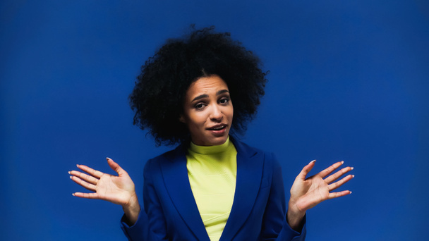 Mujer afroamericana confusa aislada en azul  - Foto, Imagen