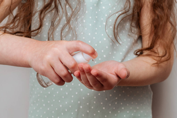 Enfant appliquant un gel antibactérien antiseptique pour la désinfection des mains contre les bactéries. Protection de la santé en cas d'épidémie de grippe, d'épidémie et de maladies infectieuses - Photo, image