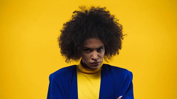 Aggressive african american woman looking at camera isolated on yellow - 写真・画像