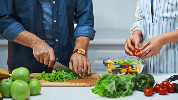 обрезанный вид пожилой пары, готовящей свежий салат на кухне - Фото, изображение