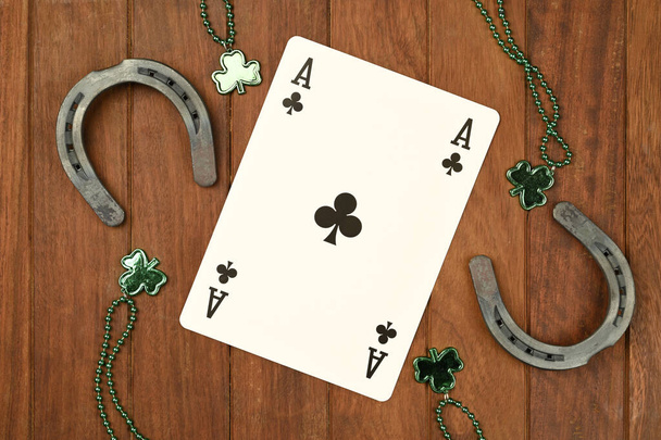 Concept de Saint Patrick. colliers de trèfle vert et fers à cheval chanceux avec des cartes de poker sur fond en bois, vue du dessus pour le texte - Photo, image