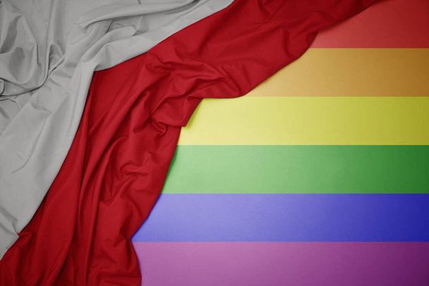 mávání barevné národní vlajky poland na pozadí gay duhové vlajky. - Fotografie, Obrázek