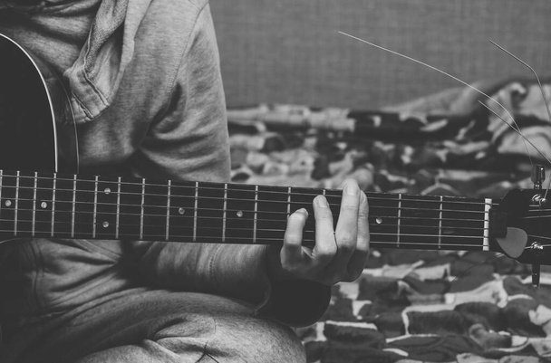The woman plays the guitar. Hand grips the strings on the fretboard - Photo, Image