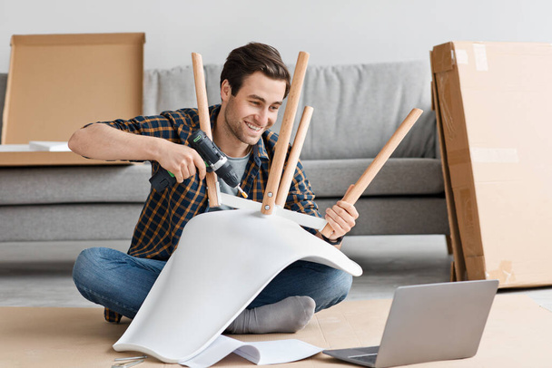 Trabalho de casa, ordenação on-line e montagem de móveis na sala de estar interior - Foto, Imagem