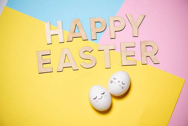 щаслива Великодня концепція. жовті яйця і паперове яйце на синьому фоні
. - Фото, зображення