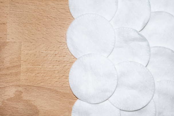 A bunch of round white cotton pads on wood background with copy-space - Photo, Image