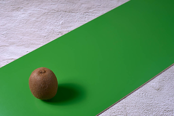 Un kiwi en el tablero verde. Fondo de piedra, diagonal - Foto, Imagen