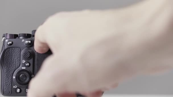 Close-up de demonstração de um display de câmera móvel. Acção. Mãos masculinas girando tela da câmera profissional isolada no fundo cinza. - Filmagem, Vídeo