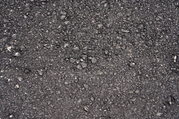 Tekstura nowego czarnego asfaltu jako tło. Przestrzeń kopiowania. - Zdjęcie, obraz