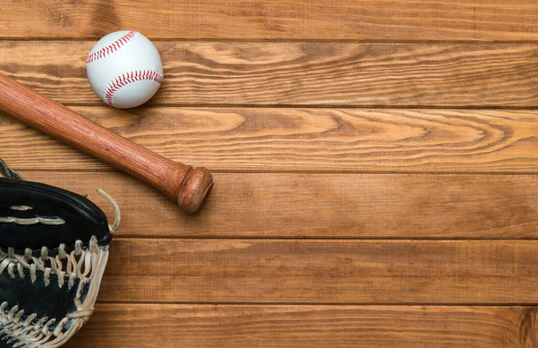 Kij baseballowy, rękawica i piłka na drewnianej podłodze. Tło tematyczne sportu z kopiowaniem tekstu i reklam - Zdjęcie, obraz