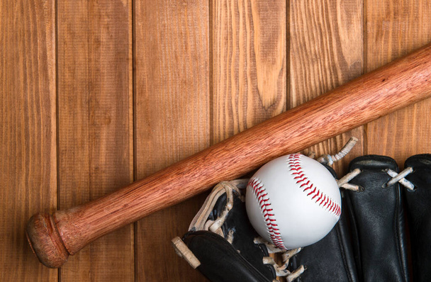 Pipistrello da baseball, guanto e palla sul pavimento in legno. Sport sfondo tema con spazio di copia per testo e pubblicità - Foto, immagini