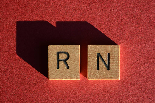 RN, абревіатура для Прямо зараз, в 3d дерев'яних літер абетки ізольовані на червоному тлі
 - Фото, зображення