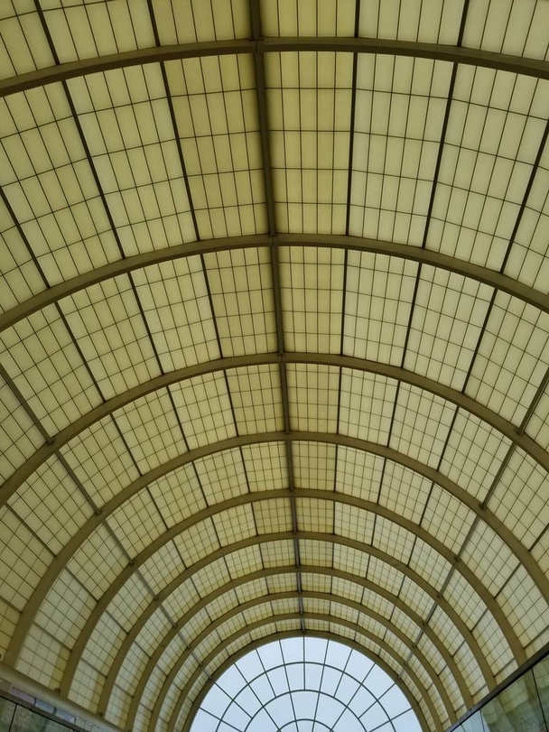 арочный стеклянный потолок с бежевыми тонами, вертикальный кадр при дневном свете - Фото, изображение