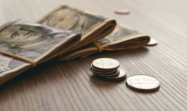 Χρήματα, δολάρια ΗΠΑ (USD) φόντο. Φωτογραφία χαρτονομισμάτων και κερμάτων σε δολάρια ΗΠΑ σε ξύλινο γραφείο. - Φωτογραφία, εικόνα