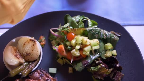 Carne a la parrilla, ensalada y cebollas asadas y chiles en el plato - Metraje, vídeo