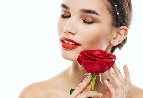 Portret van een vrouw met rode bloem oogschaduw op de oogleden wenkbrauw make-up rode lippen - Foto, afbeelding