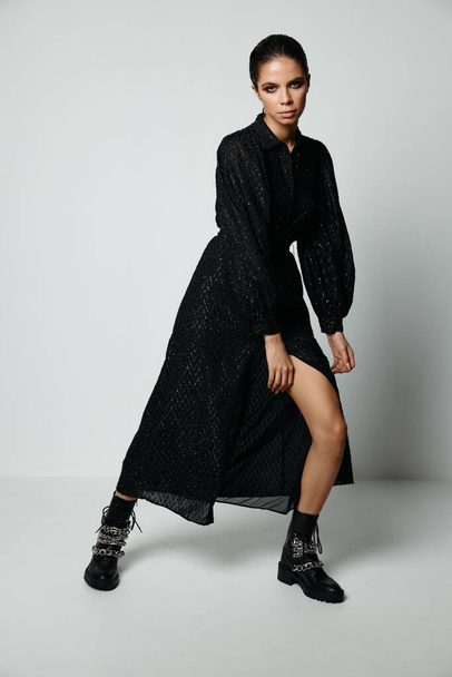 atractiva morena en vestido negro posando moda studio - Foto, imagen