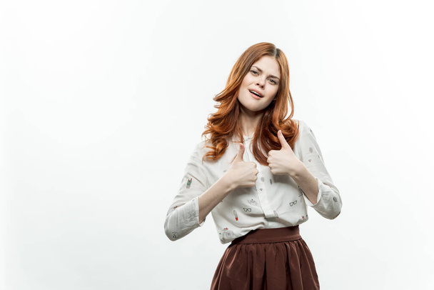 jolie femme aux cheveux roux en costume gestuelle avec les mains sourire studio - Photo, image