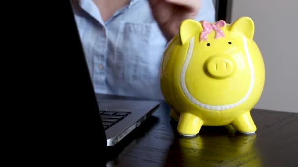 Dame in Businesskleidung steckt Münze in Sparschwein, Ersparnisse für die Zukunft, Bankeinlagen - Filmmaterial, Video