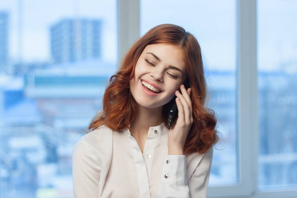 rudowłosa kobieta rozmawiająca przez telefon w biurze businesswoman job manager - Zdjęcie, obraz