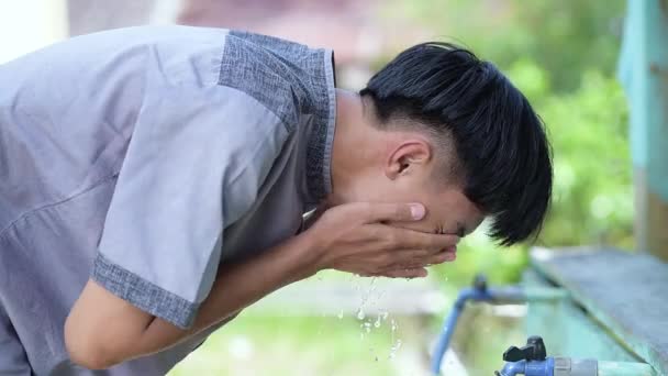 Jeune homme musulman asiatique prenant ablution pour la prière sur Ramadan Kareem à la mosquée - Séquence, vidéo