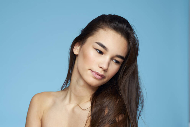 Woman with naked shoulders long hair cosmetics attractive look blue background - Zdjęcie, obraz
