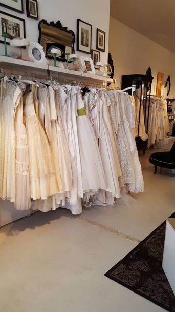 dentro de uma loja vintage com vestidos de noiva com um rack de roupas de noiva vintage e decoração - Foto, Imagem