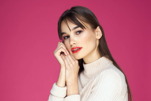 Brunette with long hair red lips cosmetics white sweater pink background cropped view - Φωτογραφία, εικόνα