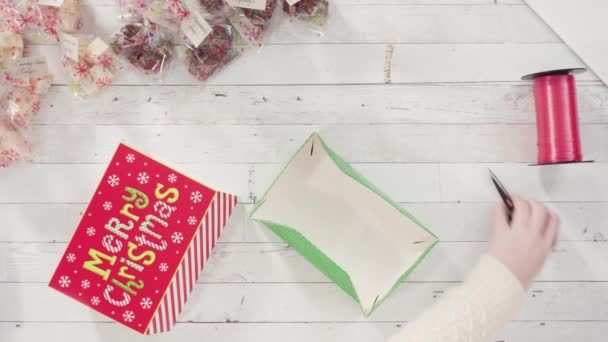 Hausgemachtes Gebäck und Plätzchen in eine Weihnachtsgeschenkbox verpacken. - Filmmaterial, Video