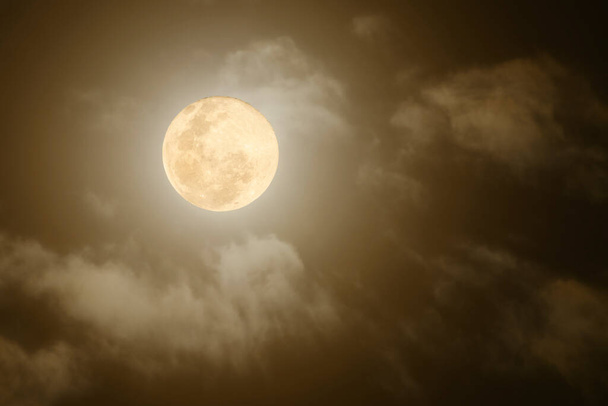 Pełnia księżyca świeci przez gęste chmury - Zdjęcie, obraz