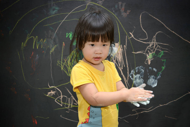 Roztomilé malé asijské dívka těší umění a řemesel malování s rukama na tabuli - Fotografie, Obrázek