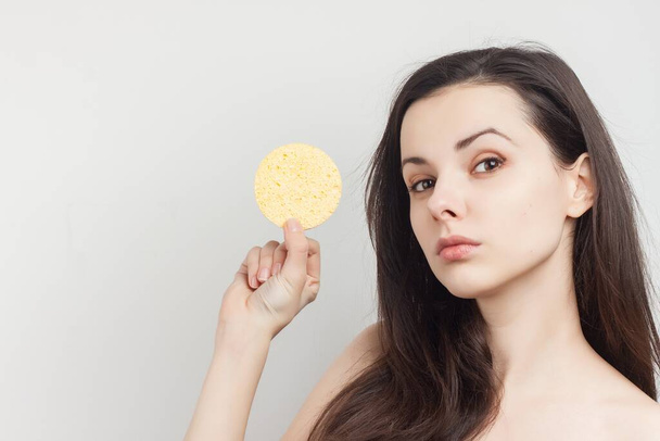 woman with bare shoulders sponges near face cosmetics care - Photo, image