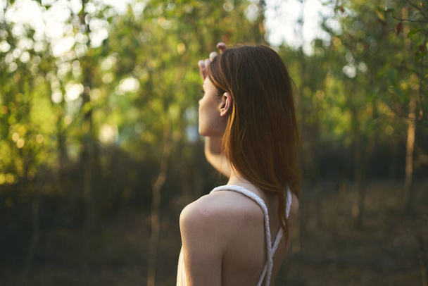 森の中の魅力的な女性緑の木の草の夏の夕日 - 写真・画像