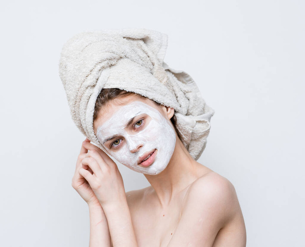 žena s ručníkem na hlavě holá ramena bílá maska na obličeji péče o pleť - Fotografie, Obrázek