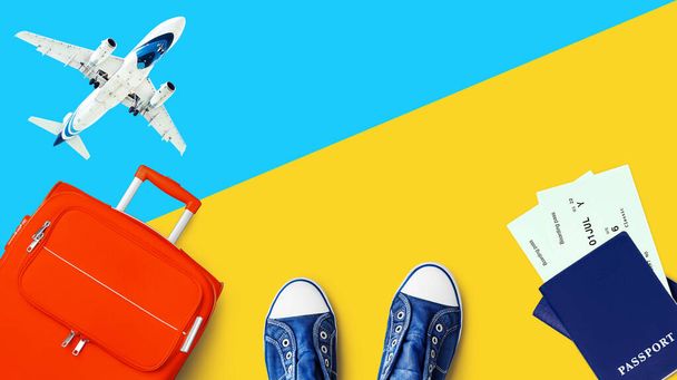 旅行バナー、夏休み、休暇のコンセプト、観光:白い飛行機、青い空、オレンジのスーツケース、パスポート、搭乗券、フライトチケット、靴黄色の背景を閉じる上のビュー、テキストコピースペース - 写真・画像