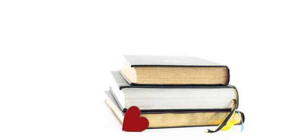 Een stapel boeken op een witte achtergrond. Rood hart. geïsoleerd - Foto, afbeelding
