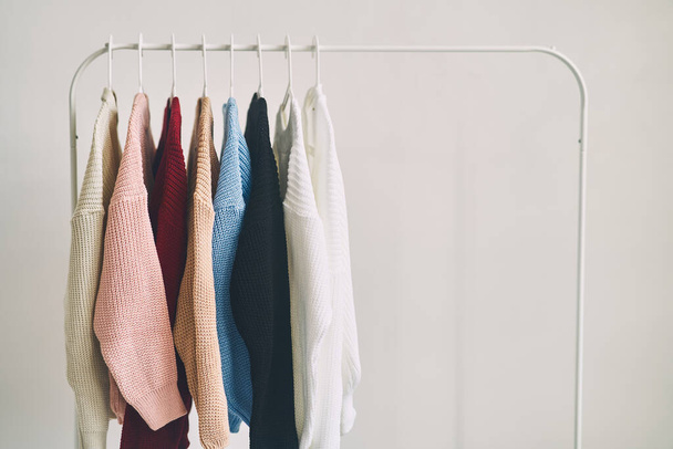 camisolas de lã de mulheres multicoloridas em cabides. Venda em uma loja de moda. Foto de alta qualidade - Foto, Imagem