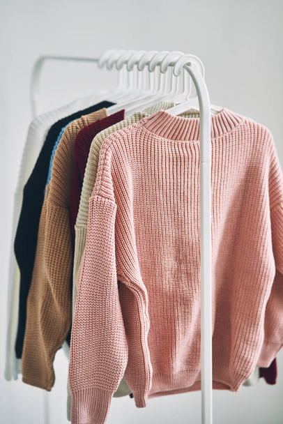 suéteres de lana multicolor de las mujeres en perchas. Venta en una tienda de moda. Foto de alta calidad - Foto, imagen