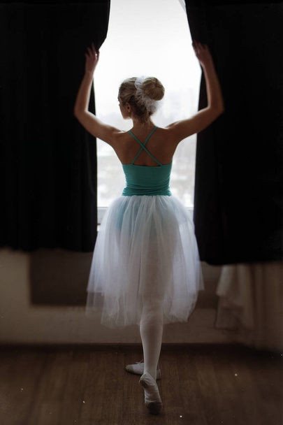 ポイントシューズの若く優雅なバレリーナとスタジオでのチュチュダンス。振付とダンスの授業のコンセプト。バレエのポーズ、パフォーマンスの創造的なアイデア。白黒写真.  - 写真・画像