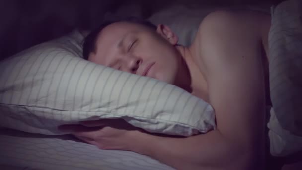 Young man goes to bed at night and immediately falls asleep - Footage, Video