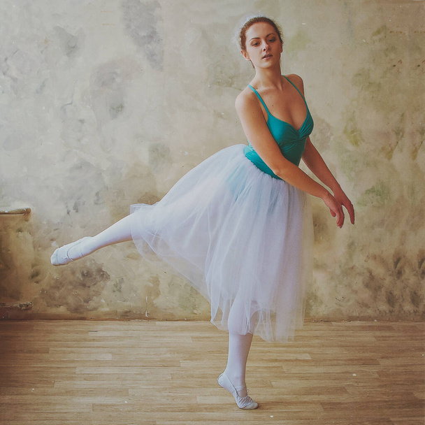 Fiatal és kecses balerina pointe cipőben és tütütánc a stúdióban. Koreográfia és táncóra koncepció. Kreatív ötletek balett pózról, előadásról. Fekete-fehér fénykép.  - Fotó, kép
